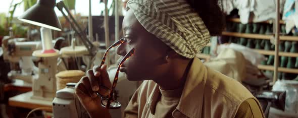 Pensive African American Woman in Shoemaker Workshop