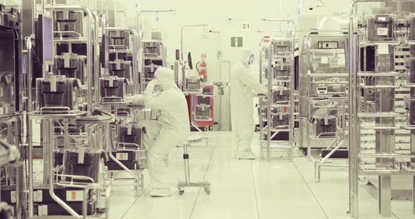 Workers in clean suits in a Semiconductor manufacturing facility