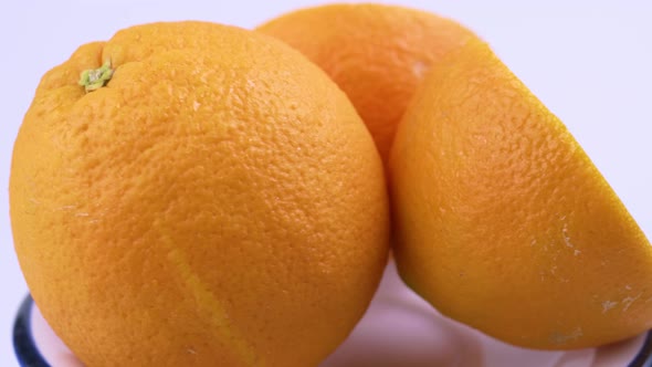 Close up fresh valencia orange sliced with white background shallow focus and slowly rotating.