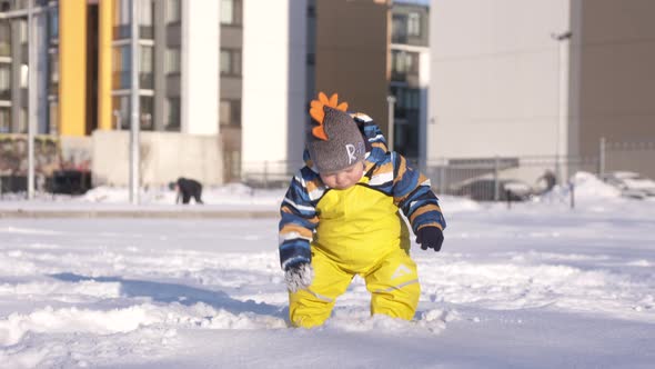 Child in Yellow Waterproof Rain Pants Bibs for Kids on Walk in Cold Season One Year Old Baby Boy