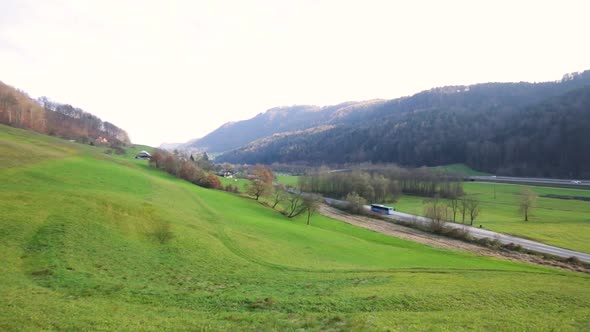 Panning over green valey with single road