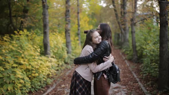 Mother and Daughter a Teenager Walking Talking and Hugging in Autumn Park