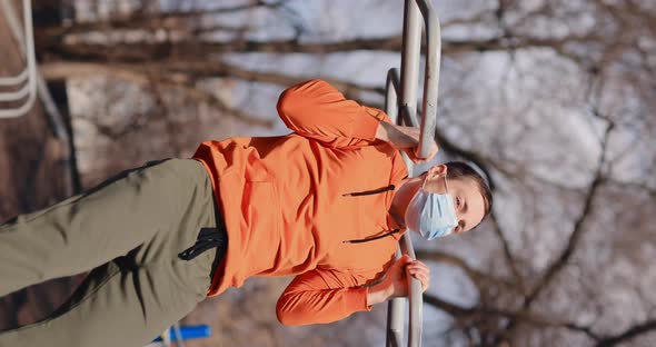 Man Pulls Up on the Bar Outdoor in a Surgical Mask Vertical Video