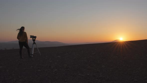 Woman filming the sunset with camera