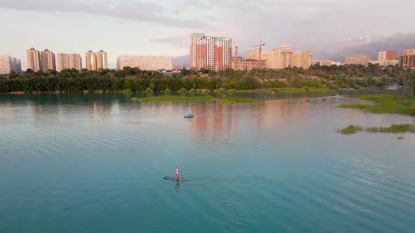 Man Ride on SUP Board in the Mountain Lake