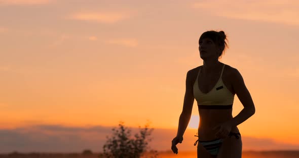 Beautiful Volleyball Girl in a Bikini at Sunset Forearm Pass Her Teammate During a Match,