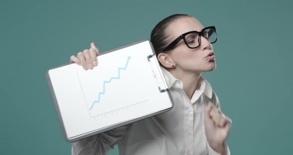 Cheerful businesswoman holding a successful financial chart and smiling