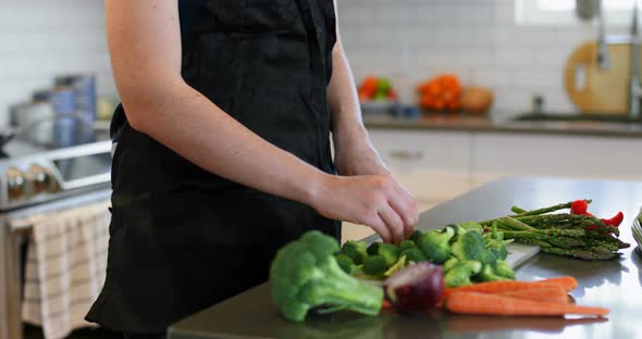 Woman chopping vegetable in kitchen at home 4k