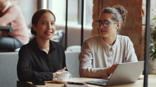 Two Young Beautiful Businesswomen Posing Together for Camera in Cafe