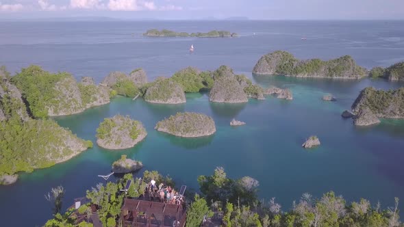 drone footage of a lagoon in Raja Ampat, Indonesia. showing people standing at a viewpoint looking o