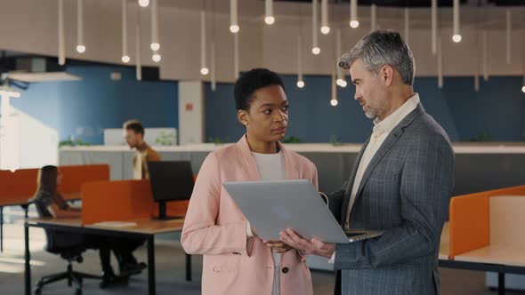 Male and Female Coworkers Discussing Current Project and Looking at Laptop Screen