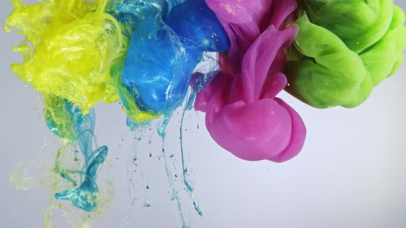 Colorful nacreous paint in water against white background.