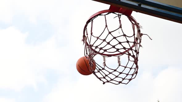 Shooting orange basketball ball into the basket