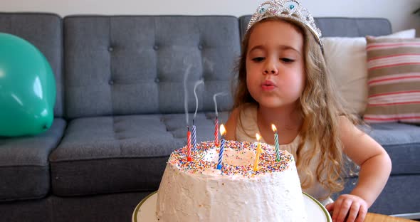 Girl blowing candles on birthday cake
