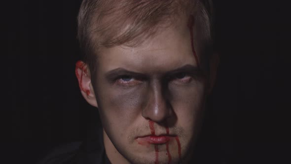 Halloween Man Portrait. Guy with Dripping Blood on His Face. Scary Makeup