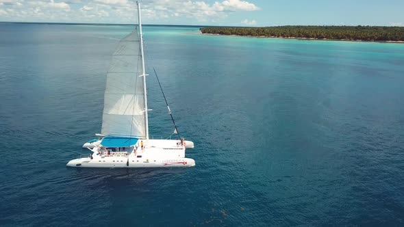 drone shoot of the catamaran in the saona island in the caribbean sea with blue water in a sunny day