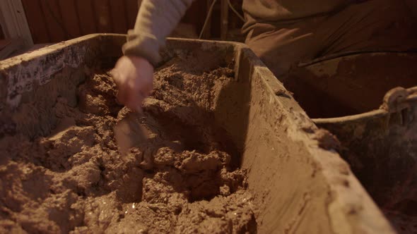 The clay mix being scooped out and into the plasterers bucket