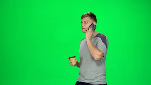 Young Male Walking Talking on the Phone and Drinking Coffee. Chroma Key