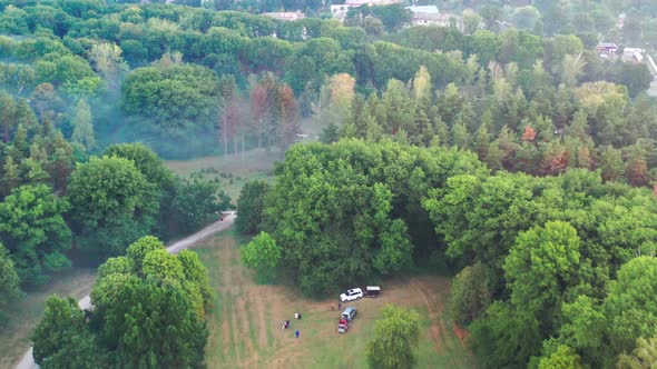 Nice top view of the park, forest covered with greenery. Small houses in the background.