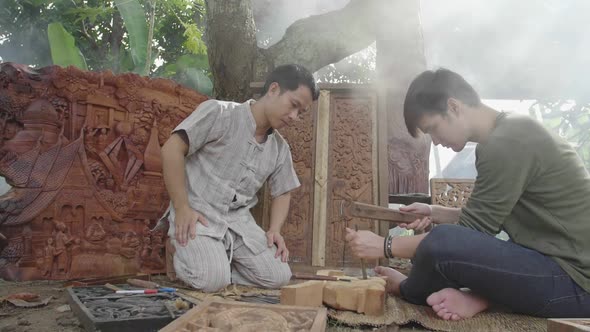 Young Man Learning To Carve Wooden To His Teacher