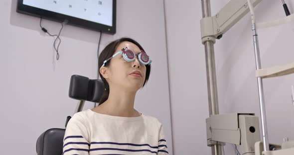 Asian Woman diagnosis eye test in clinic