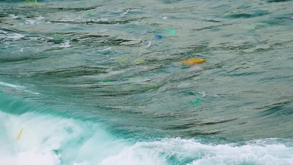 Close up on sea wave carry plastic rubbish polluting environment