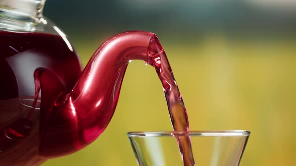 Pouring Red Fruit Tea Into Glass Cup Closeup