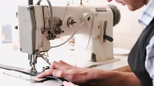 The Craftsman Stitches a Men's Leather Belt on a Sewing Machine