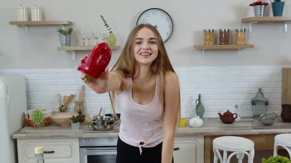 Girl Recommending Eating Raw Vegetable Food. Showing Pepper in Hands. Weight Loss and Diet Concept