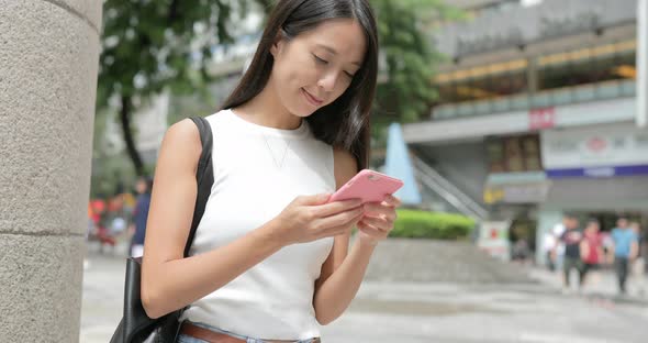 Young Woman working on smart phone in the city 