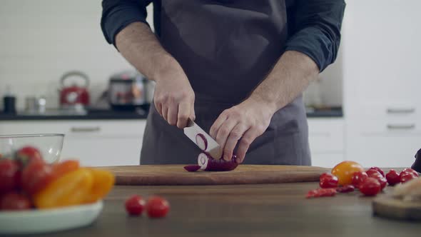 The chef chops vegetables in the home kitchen. Cutting vegetables for healthy food. 