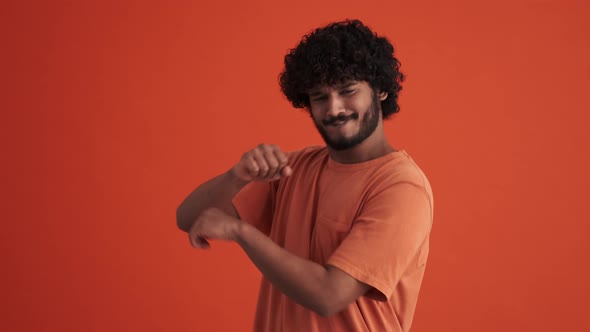Handsome curly-haired Indian man dancing