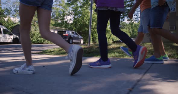 Kids walking on sidewalk close up feet