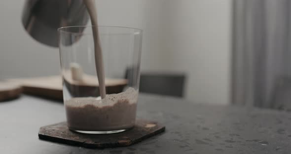Slow Motion Hot Chocolate Pour Into Tumbler Glass on Countertop