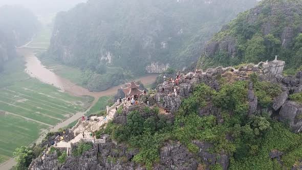 Aerial from the top of Vietnamese dragon temple on top of large limestone karst. Hang Mua, Tam Coc,