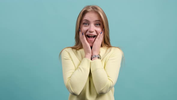 Attractive Young Woman Having Stunned and Shocked Look on a Turquoise Background.