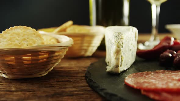 Cheese, olive and salami on table