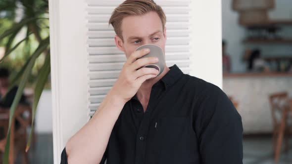 Portrait of Handsome Man Drinks Delicious Coffee in Stylish Bright Cafe