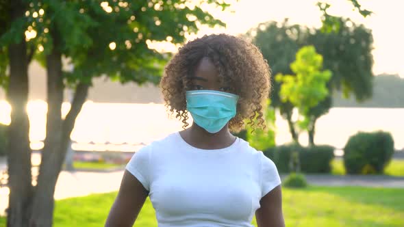 African American Girl in Medical Mask for the Prevention of Coronavirus and Looking at the Camera in