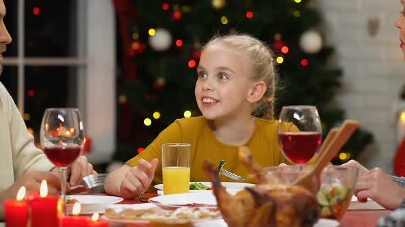 Little Girl Communicating With Parents at Christmas Dinner, Family Celebration