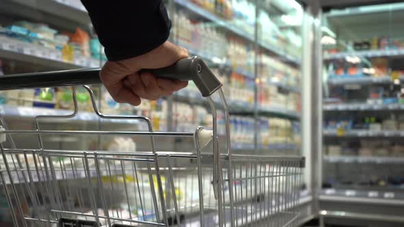 Senior Hands Pushing Trolley in Supermarket Department Store or Shopping Mall