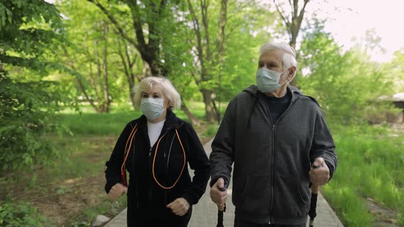 Active Senior Old Man, Woman Training Nordic Walking in Park During Quarantine