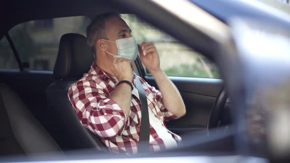 Confident Adult Man Putting on Covid19 Face Mask and Getting Out of Car