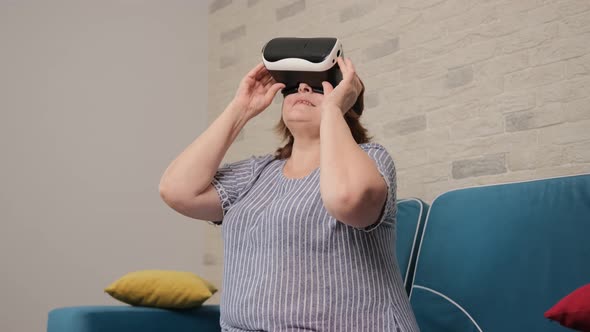 Aged Woman Watching a Video Using a Virtual Reality Glasses