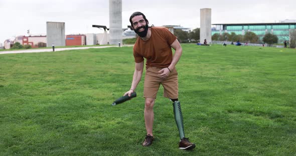 Young man holding a part of his leg prosthesis at city park