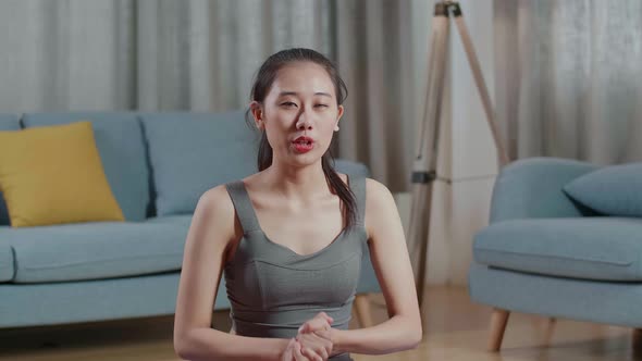 Asian Trainer Female In Sports Clothes Waving Hand And Speaking While Teaching Exercise At Home