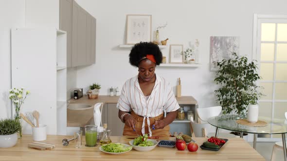 African American Woman Making Salad at Kitchen