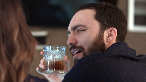 Cute couple talking and having a drink in a bar