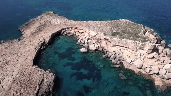 Aerial Orbit Shot of a Secret Moon-shaped Island in the North of Ibiza On Turquoise Waters