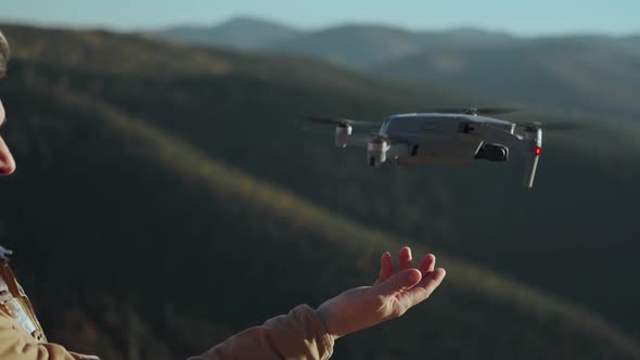 Close Up Hand of Professional Drone Operator and Aerial Photographer Landing Drone on His Hand After